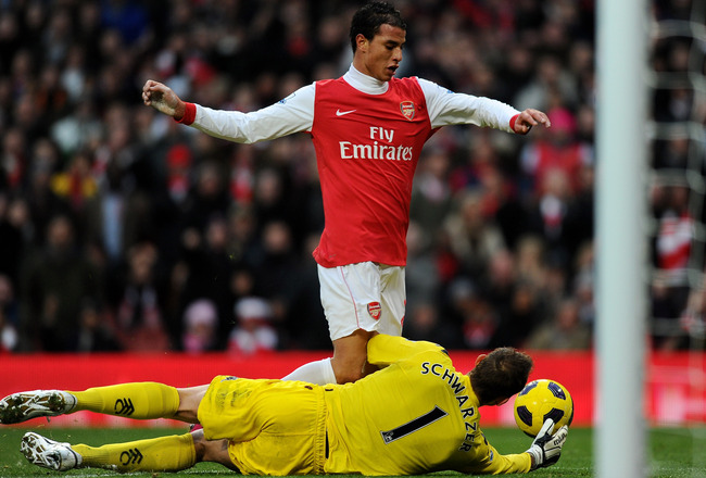 LONDON, ENGLAND - DECEMBER 04:  Marouane Chamakh (up) of Arsenal is tackled by Mark Schwarzer of Fulham during the Barclays Premier League match between Arsenal and Fulham at the Emirates Stadium on December 4, 2010 in London, England.  (Photo by Mike Hewitt/Getty Images)
