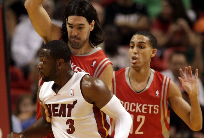 MIAMI, FL - MARCH 27:  Guard Dwyane Wade of the Miami Heat drives against gurad Kevin Martin #12 and forward Luis Scola #4 of the Houston Rockets at American Airlines Arena on March 27, 2011 in Miami, Florida. NOTE TO USER: User expressly acknowledges and agrees that, by downloading and/or using this Photograph, User is consenting to the terms and conditions of the Getty Images License Agreement.  (Photo by Marc Serota/Getty Images)