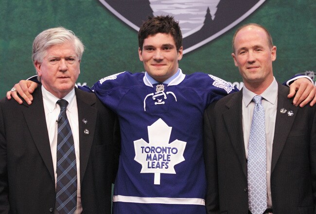 ST PAUL, MN - JUNE 24:  22nd overall pick Tyler Biggs by the Toronto Maple Leafs stands onstage for a photo with President & General Manager Brian Burke (L) and a member of the Toronto Maple Leafs organization during day one of the 2011 NHL Entry Draft at Xcel Energy Center on June 24, 2011 in St Paul, Minnesota.  (Photo by Bruce Bennett/Getty Images)