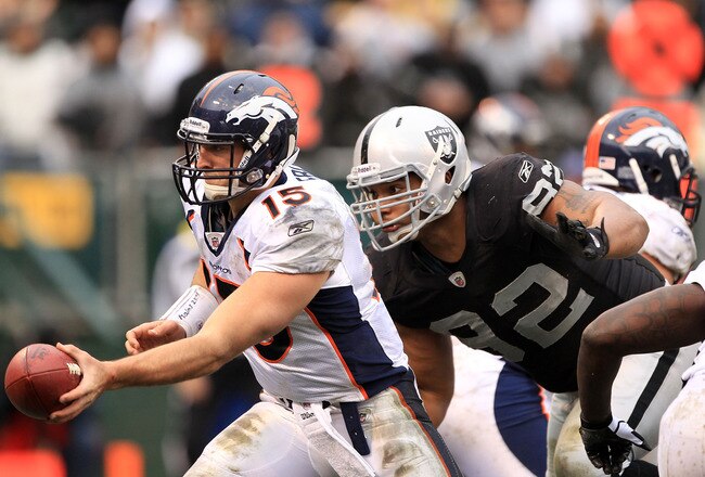 OAKLAND, CA - DECEMBER 19:  Tim Tebow #15 of the Denver Broncos hands off the ball before being hit by Richard Seymour #92 of the Oakland Raiders at Oakland-Alameda County Coliseum on December 19, 2010 in Oakland, California.  (Photo by Ezra Shaw/Getty Images)