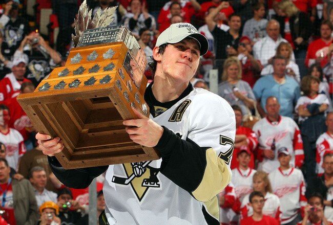 DETROIT - JUNE 12:  Evgeni Malkin #71 of the Pittsburgh Penguins hold up the Conn Smythe MVP Trophy after a 2-1 win over the Detroit Red Wings during Game Seven of the 2009 NHL Stanley Cup Finals at Joe Louis Arena on June 12, 2009 in Detroit, Michigan.  (Photo by Jim McIsaac/Getty Images)