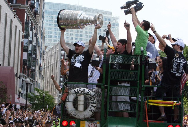 BOSTON, MA  - JUNE 18: Milan Lucic of the Boston Bruins holds the Stanley Cup up to the cheering fans during the Stanley Cup victory parade on June 18, 2011 in Boston, Massachusetts.  (Photo by Gail Oskin/Getty Images)
