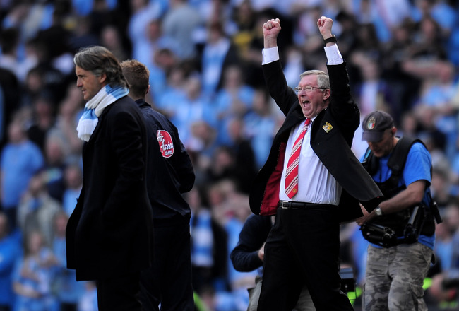 MANCHESTER, ENGLAND - APRIL 17:  Manchester United Manager Sir Alex Ferguson celebrates as Manchester City Manager Roberto Mancini looks on during the Barclays Premier League match between Manchester City and Manchester United at the City of Manchester Stadium on April 17, 2010 in Manchester, England.  (Photo by Shaun Botterill/Getty Images)