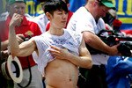 NEW YORK - JULY 4:   Takeru Kobayashi of Nagano, Japan sticks out his fully belly after Joey Chestnut of San Jose, California defeated him in the Nathan's Famous Fourth of July hot dog eating contest on on July 4, 2009 in Coney Island in the Brooklyn borough of New York City.  Chestnut defeated Kobayashi with eating 68 to his 64.5 hotdogs. Kobayashi won six previous competitions before tying last year with Chestnut.  (Photo by Yana Paskova/Getty Images)