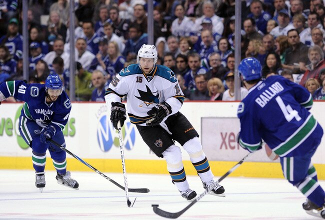 VANCOUVER, CANADA - MAY 24:  Dany Heatley #15 of the San Jose Sharks skates the puck through the neutral zone against Keith Ballard #4 of the Vancouver Canucks in the first period in Game Five of the Western Conference Finals during the 2011 Stanley Cup Playoffs at Rogers Arena on May 24, 2011 in Vancouver, British Columbia, Canada. (Photo by Harry How/Getty Images)