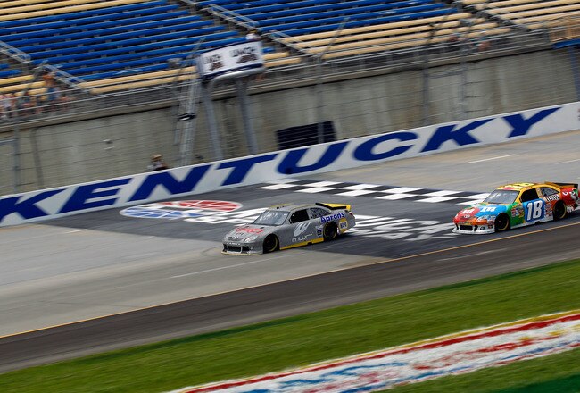 SPARTA, KY - JULY 07:  Mike Skinner drives the #124 Michael Waltrip Racing Toyota with the electronic fuel injection system along side of Kyle Busch, driver of the #18 M&M's Toyota, during testing for the NASCAR Sprint Cup Series at Kentucky Speedway on July 7, 2011 in Sparta, Kentucky.  (Photo by Chris Graythen/Getty Images)