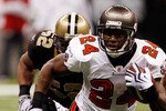 NEW ORLEANS - DECEMBER 27:  Cadillac Williams #24 of the Tampa Bay Buccaneers runs past Jonathan Casillas #52  of the New Orleans Saints at the Louisiana Superdome on December 27, 2009 in New Orleans, Louisiana.  (Photo by Chris Graythen/Getty Images)