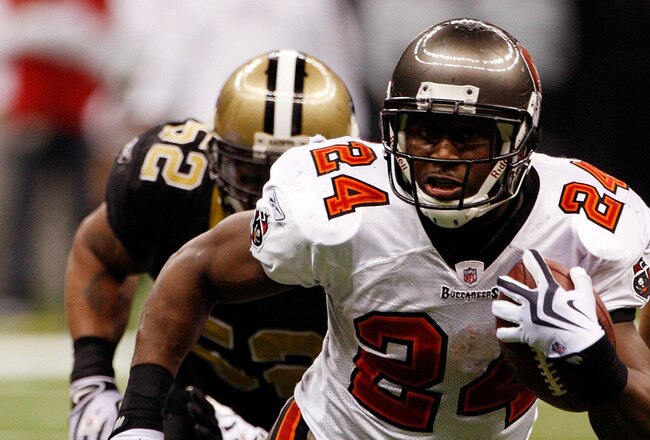 NEW ORLEANS - DECEMBER 27:  Cadillac Williams #24 of the Tampa Bay Buccaneers runs past Jonathan Casillas #52  of the New Orleans Saints at the Louisiana Superdome on December 27, 2009 in New Orleans, Louisiana.  (Photo by Chris Graythen/Getty Images)