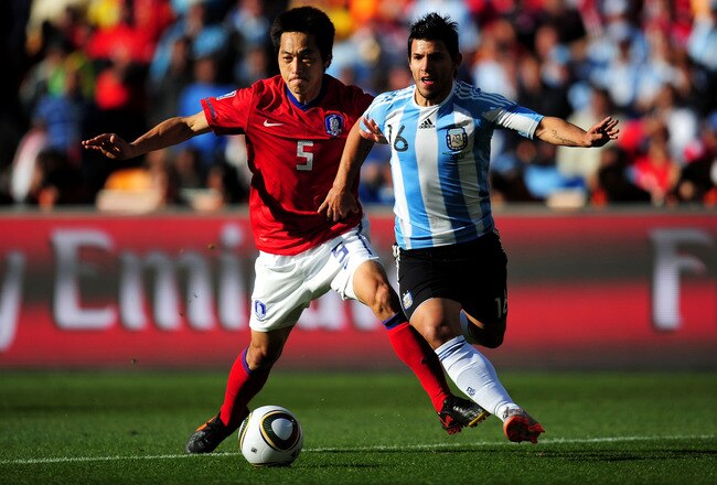 JOHANNESBURG, SOUTH AFRICA - JUNE 17:  Kim Nam-Il of South Korea and Sergio Aguero of Argentina tussle for the ball during the 2010 FIFA World Cup South Africa Group B match between Argentina and South Korea at Soccer City Stadium on June 17, 2010 in Johannesburg, South Africa.  (Photo by Clive Mason/Getty Images)