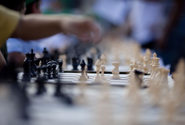 TEL AVIV, ISRAEL - OCTOBER 21: (ISRAEL OUT) A Israeli chess player makes a move against Grandmaster Alik Gershon, during an attempt to break the Guinness world record of simultaneous chess play on October 21, 2010 in Tel Aviv, Israel. Hundreds of chess players in Israel are attempting to break the Guinness world record of simultaneous chess play. Iran currently holds the world record of 500 games played simultaneously.  (Photo by Uriel Sinai/Getty Images)