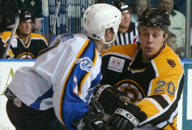 BRIDGEPORT, CT - FEBRUARY 4: Garret Stroshein #20 of the Providence Bruins skates against Vince Macri #7 of the Bridgeport Sound Tigers at the Arena at Harbor Yard on February 4, 2006 in Bridgeport, Connecticut. The Tigers won 4-1. (Photo by Mike Stobe/Getty Images)