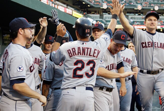 BALTIMORE, MD - JULY 15: Michael Brantley #23 of the Cleveland Indians celebrates scoring against the Baltimore Orioles with teammates in the dugout during the third inning at Oriole Park at Camden Yards on July 15, 2011 in Baltimore, Maryland.  (Photo by Rob Carr/Getty Images)