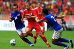 KUALA LUMPUR, MALAYSIA - JULY 16: Joe Cole of Liverpool evades tackle from Abdul Hadi Yahaya and Mahalli Jasuli of Malaysia during the pre-season friendly match between Malaysia and Liverpool at the Bukit Jalil National Stadium on July 16, 2011 in Kuala Lumpur, Malaysia. (Photo by Stanley Chou/Getty Images)