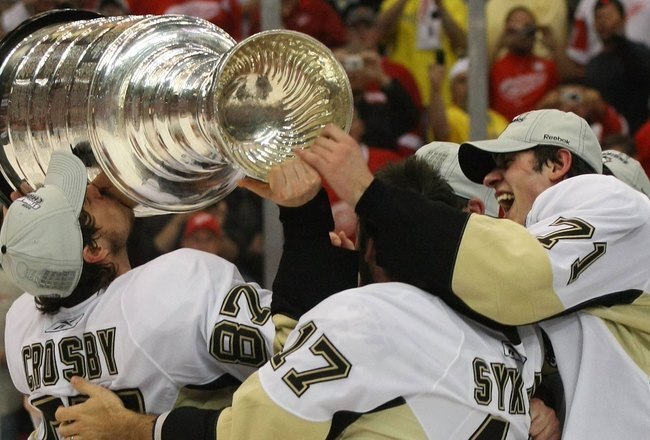 DETROIT - JUNE 12: (L-R) Sidney Crosby #87, Petr Sykora and Evgeni Malkin #71 of the Pittsburgh Penguins celebrate with the Stanley Cup following the Penguins victory over the Detroit Red Wings in Game Seven of the 2009 NHL Stanley Cup Finals at Joe Louis Arena on June 12, 2009 in Detroit, Michigan. (Photo by Bruce Bennett/Getty Images)