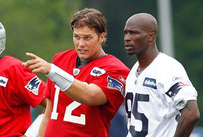 FOXBOROUGH, MA  - JULY 29:  Tom Brady #12 and Chad Ochocinco #85 of the New England Patriots chats during the afternoon session of training camp at Gillette Stadium on July 29, 2011 in Foxborough, Massachusetts.  (Photo by Jim Rogash/Getty Images)