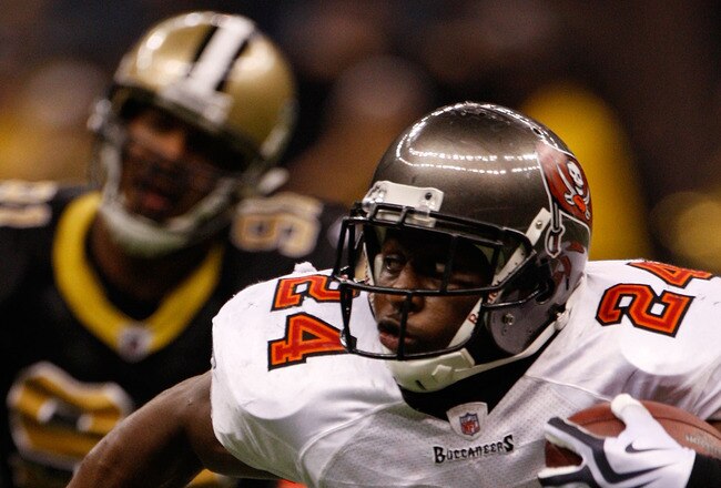 NEW ORLEANS - DECEMBER 27:  Cadillac Williams #24 of the Tampa Bay Buccaneers runs past Will Smith #91 of the New Orleans Saints at the Louisiana Superdome on December 27, 2009 in New Orleans, Louisiana.  (Photo by Chris Graythen/Getty Images)