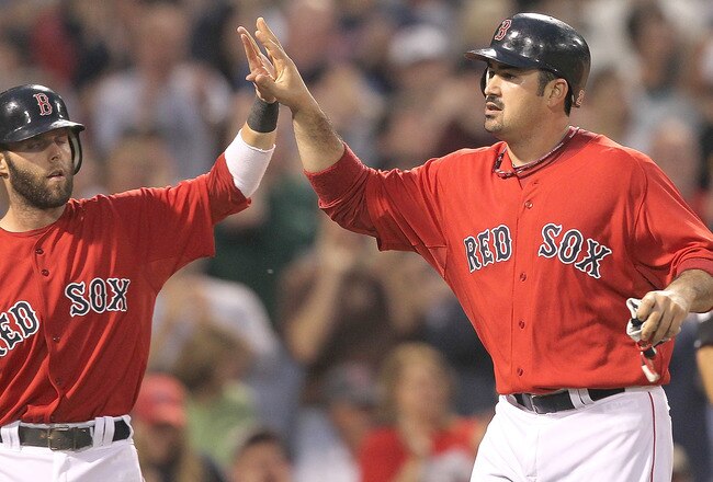BOSTON, MA  - JUNE 17:  Dustin Pedroia #15 and Adrian Gonzalez #28 of the Boston Red Sox celebrate after they scored runs in the third inning on a hit by KevinYoukillis #20 against the Milwaukee Brewers at Fenway Park on June 17, 2011 in Boston, Massachusetts.  (Photo by Jim Rogash/Getty Images)