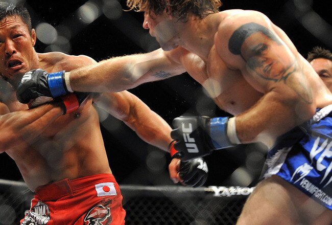LAS VEGAS - JULY 11:  (R-L) Alan Belcher throws a right at Yoshihiro Akiyama during their middleweight bout during UFC 100 on July 11, 2009 in Las Vegas, Nevada.  (Photo by Jon Kopaloff/Getty Images)
