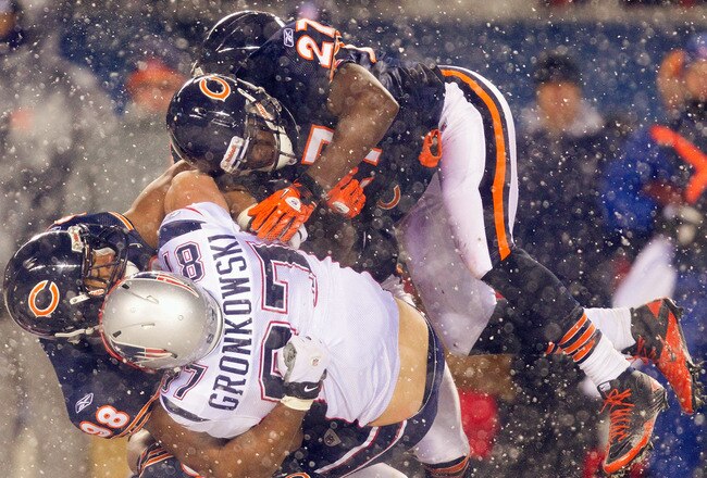 CHICAGO, IL - DECEMBER 12: Major Wright #27 and Corey Wooten #98  both of the Chicago Bears tackle Rob Gronkowski #87 of the New England Patriots at Soldier Field on December 12, 2010 in Chicago, Illinois.  The Patriots beat the Bears 36-7.  (Photo by Dilip Vishwanat/Getty Images)
