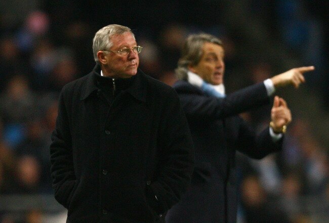 MANCHESTER, ENGLAND - JANUARY 19:  Manchester United Manager Sir Alex Ferguson looks on as Manchester City Manager Roberto Mancini gestures during the Carling Cup Semi Final match between Manchester City and Manchester United at the City of Manchester Stadium on January 19, 2010 in Manchester, England.  (Photo by Alex Livesey/Getty Images)