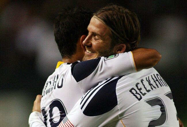 CARSON, CA - AUGUST 06:  David Beckham #23 of the Los Angeles Galaxy hugs teammate Juninho #19 after he assisted on a goal by Juninho against FC Dallas at The Home Depot Center on August 6, 2011 in Carson, California.  (Photo by Jeff Golden/Getty Images)