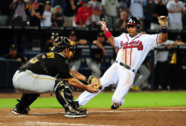 ATLANTA - JULY 26: Julio Lugo #28 of the Atlanta Braves scores the game-winning run in the 19th inning against Michael McKenry #55 of the Pittsburgh Pirates at Turner Field on July 26, 2011 in Atlanta, Georgia. (Photo by Scott Cunningham/Getty Images)