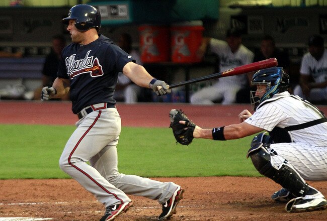 MIAMI GARDENS, FL - AUGUST 08:  Dan Uggla #26 of the Atlanta Braves gets a hit in the fifth inning against the Florida Marlins at Sun Life Stadium on August 8, 2011 in Miami Gardens, Florida.  (Photo by Marc Serota/Getty Images)