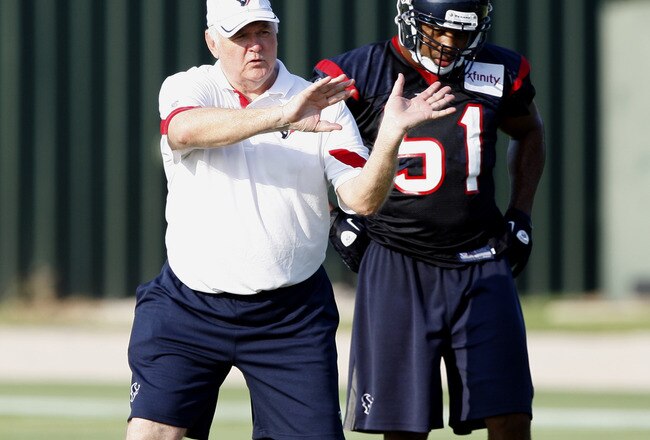 HOUSTON, TX - AUGUST 01:  Defensive Coordinator Wade Phillips of the Houston Texans goes over plays with inside linebacker Darryl Sharpton #51 during practice on the first day of training camp at Reliant Park on August 1, 2011 in Houston, Texas.  (Photo by Bob Levey/Getty Images)