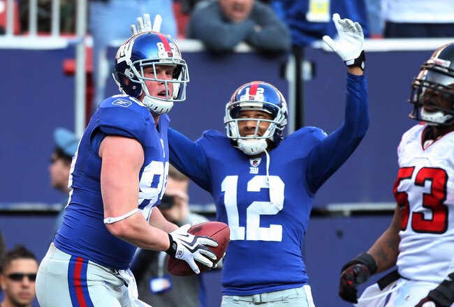 EAST RUTHERFORD, NJ - NOVEMBER 22:  Kevin Boss #89 of the New York Giants celebrates his first touchdown with teammate Steve Smith #12 as Mike Peterson #53 of the Atlanta Falcons on November 22, 2009 at Giants Stadium in East Rutherford, New Jersey.  (Photo by Jim McIsaac/Getty Images)