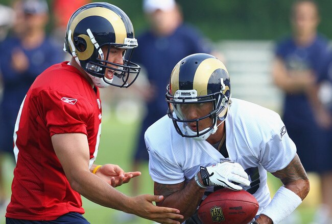 EARTH CITY, MO - JULY 31:  Sam Bradford #8 of the St. Louis Rams hands the ball off to teammate Austin Pettis #83 during training camp at the Russell Training Center on July 31, 2011 in Earth City, Missouri.  (Photo by Dilip Vishwanat/Getty Images)