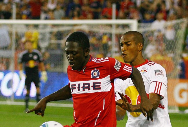HARRISON, NJ - AUGUST 13: Patrick Nyarko #14 of the Chicago Fire plays the ball while being defended by Roy Miller #7 of the New York Red Bulls during the game at Red Bull Arena on August 13, 2011 in Harrison, New Jersey. (Photo by Andy Marlin/Getty Images)
