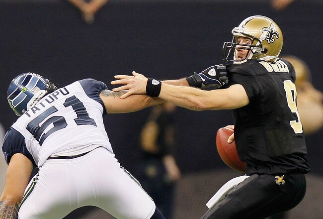 NEW ORLEANS - NOVEMBER 21:  Quarterback Drew Brees #9 of the New Orleans Saints breaks away from a tackle by Lofa Tatupu #51 of the Seattle Seahawks at Louisiana Superdome on November 21, 2010 in New Orleans, Louisiana.  (Photo by Kevin C. Cox/Getty Images)