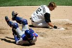 CHICAGO - MAY 20:  A.J. Pierzynski #12 of the Chicago White Sox slaps home base after colliding with Michael Barrett #8 of the Chicago Cubs on a sacrifice fly in the second inning on May 20, 2006 at U.S. Cellular Field in Chicago, Illinois.  (Photo by Jonathan Daniel/Getty Images)