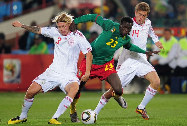 PRETORIA, SOUTH AFRICA - JUNE 19:  Vincent Aboubakar of Cameroon is tackled by Simon Kjaer (L) and Jakob Poulsen of Denmark during the 2010 FIFA World Cup South Africa Group E match between Cameroon and Denmark at Loftus Versfeld Stadium on June 19, 2010 in Tshwane/Pretoria, South Africa.  (Photo by Clive Mason/Getty Images)