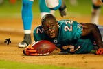 MIAMI GARDENS, FL - AUGUST 19:  Reggie Bush #22 of the Miami Dolphins loses his helmet during a Preseason NFL game against the Carolina Panthers at Sun Life Stadium on August 19, 2011 in Miami Gardens, Florida.  (Photo by Mike Ehrmann/Getty Images)