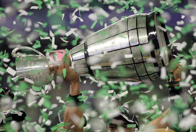 TORONTO, ON - NOVEMBER 25:  Quarterback Kerry Joseph #4 of the Saskatchewan Rough Riders hoists the trophy as confetti falls in celebration of a 23-19 victory over the Winnipeg Blue Bombers during the 95th Grey Cup on November 25, 2007 at the Rogers Centre in Toronto, Ontario, Canada.  (Photo by Harry How/Getty Images)