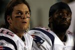 MIAMI - OCTOBER 04:  Quarterback Tom Brady #12 and Randy Moss of the New England Patriots sit on the sidelines  against the Miami Dolphins at Sun Life Stadium on October 4, 2010 in Miami, Florida.  (Photo by Marc Serota/Getty Images)