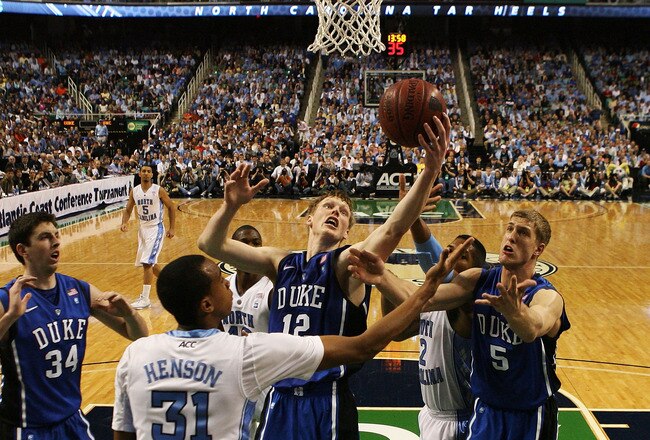 GREENSBORO, NC - MARCH 13:  Kyle Singler #12 and Mason Plumlee #5 of the Duke Blue Devils rebound against John Henson #31 of the North Carolina Tar Heels during the first half in the championship game of the 2011 ACC men's basketball tournament at the Greensboro Coliseum on March 13, 2011 in Greensboro, North Carolina. Duke won 75-58 in regulation. (Photo by Streeter Lecka/Getty Images)