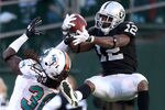 OAKLAND, CA - NOVEMBER 28:  Jacoby Ford #12 of the Oakland Raiders catches the ball while defended by Chris Clemons #30 of the Miami Dolphins at Oakland-Alameda County Coliseum on November 28, 2010 in Oakland, California.  (Photo by Ezra Shaw/Getty Images)