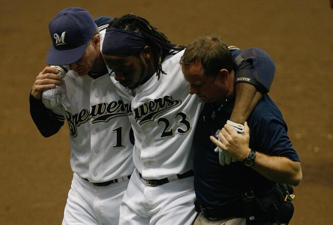 MILWAUKEE, WI - JULY 27: Rickie Weeks #23 of the Milwaukee Brewers is carried off the field by Ron Roenicke and a trainer after an injury against the Chicago Cubs at Miller Park on July 27, 2011 in Milwaukee, Wisconsin.  The Brewers defeated the Cubs 2-0. (Photo by Scott Boehm/Getty Images)