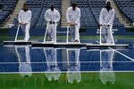 NEW YORK, NY - SEPTEMBER 07:  Workers dry the court at Arthur Ashe Stadium during Day Ten of the 2011 US Open at the USTA Billie Jean King National Tennis Center on September 7, 2011 in the Flushing neighborhood of the Queens borough of New York City.  (Photo by Patrick McDermott/Getty Images)