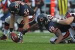 CHICAGO, IL - SEPTEMBER 11: Brian Urlacher #54 of the Chicago Bears pics up a fumble that's out of the reach of teammate Julius Peppers #90 as Sam Baker #72 of the Atlanta Falcons holds back Peppers at Soldier Field on September 11, 2011 in Chicago, Illinois. The Bears defeated the Falcons 30-12. (Photo by Jonathan Daniel/Getty Images)