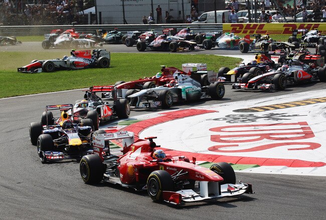 MONZA, ITALY - SEPTEMBER 11:  Fernando Alonso of Spain and Ferrari leads into the first corner as in the background Vitantonio Liuzzi of Italy and Hispania Racing Team loses control of his car at the start of the Italian Formula One Grand Prix at the Autodromo Nazionale di Monza on September 11, 2011 in Monza, Italy.  (Photo by Mark Thompson/Getty Images)