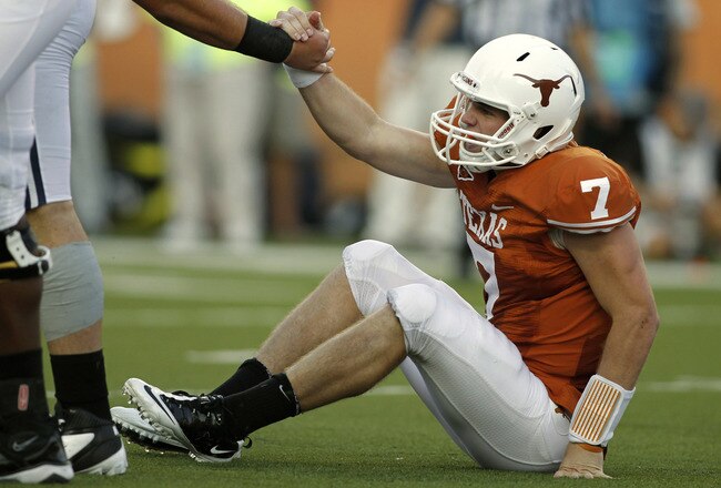 AUSTIN, TX Ð SEPTEMBER 10:  Quarterback Garrett Gilbert #7 of the Texas Longhorns is helped up after being sacked in the second quarter against the BYU Cougars on September 10, 2011 at Darrell K. Royal-Texas Memorial Stadium in Austin, Texas.  Texas defeated BYU 17-16. (Photo by Erich Schlegel/Getty Images)