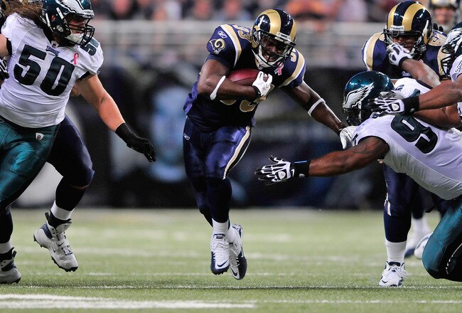 ST. LOUIS, MO - SEPTEMBER 11: Cadillac Williams #33 of the St. Louis Rams runs and pushes off of Cullen Jenkins #97 of the Philadelphia Eagles at the Edward Jones Dome on September 11, 2011 in St. Louis, Missouri. The Eagles defeated the Rams 31-15. (Photo by Jeff Curry/Getty Images)