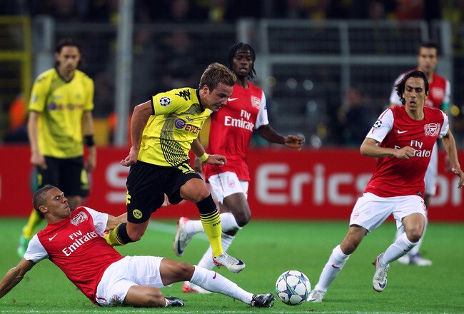 DORTMUND, GERMANY - SEPTEMBER 13:  Kieran Gibbs (L) of Arsenal tries to tackle Mario Gotze (C) of Borussia Dortmund next to Yossi Benayoun of Arsenal during the UEFA Champions League Group F match between Borussia Dortmund and Arsenal FC at Signal Iduna Park on September 13, 2011 in Dortmund, Germany.  (Photo by Ian Walton/Getty Images)