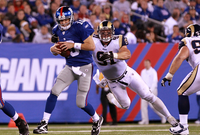 EAST RUTHERFORD, NJ - SEPTEMBER 19:  Eli Manning #10 of the New York Giants is sacked by Chris Long #91 of the St. Louis Rams at MetLife Stadium on September 19, 2011 in East Rutherford, New Jersey.  (Photo by Nick Laham/Getty Images)