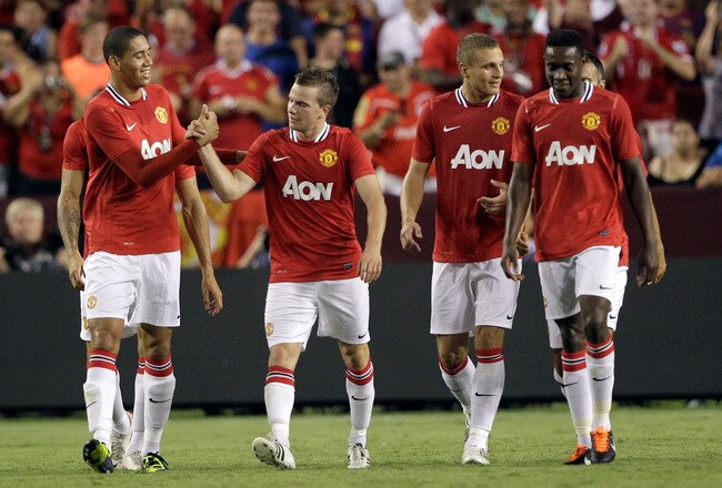 LANDOVER, MD - JULY 30: Chris Smalling #12 (L) celebrates with teammate Michael Owen #7 (R) of Manchester United after Owen scored against Barcelona during the second half of a friendly match at FedExField on July 30, 2011 in Landover, Maryland. Manchester United won 2-1. (Photo by Rob Carr/Getty Images)