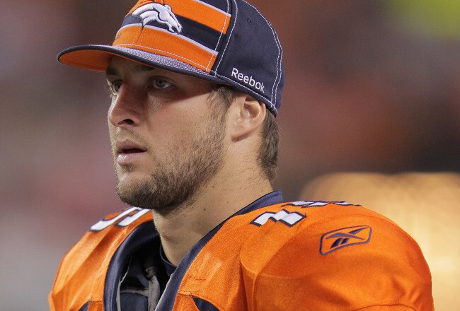 DENVER, CO - SEPTEMBER 12:  Quarterback  Tim Tebow #15 of the Denver Broncos looks on from the bench against the Oakland Raiders at Sports Authority Field at Mile High on September 12, 2011 in Denver, Colorado. The Raiders defeated the Broncos 23-20.  (Photo by Doug Pensinger/Getty Images)