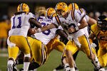 MORGANTOWN, WV - SEPTEMBER 24: Jarrett Lee #12 of the Louisiana State University Tigers hands the ball off to teammate Spencer Ware #11 during the game against the West Virginia Mountaineers on September 24, 2011 at Mountaineer Field in Morgantown, West Virginia.  (Photo by Jared Wickerham/Getty Images)